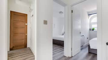 2 habitaciones, escritorio y tabla de planchar con plancha