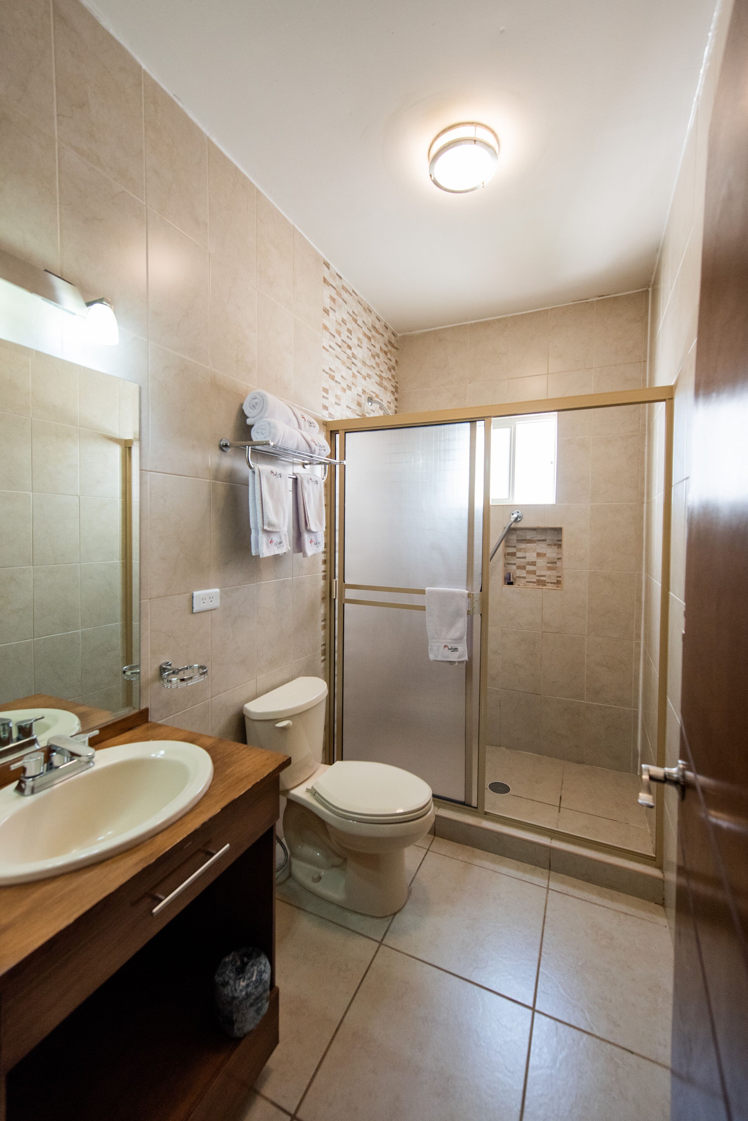 A modern bathroom with a sink, toilet, and glass-enclosed shower.