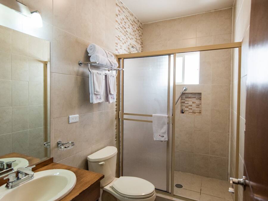A modern bathroom with a sink, toilet, and glass-enclosed shower.