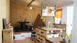 A rustic kitchen with wooden walls, a wooden table, and a hanging plant. - Refúgio Saloio in Lousa-LRS (Lousa)