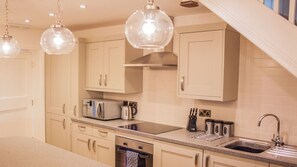 A modern kitchen with light-colored cabinets, a built-in oven, a sink, and a coffee maker. - Rosedale Cottage | sleeps 4 - Hot Tub, Dog Friendly - 5* Gold Award (Pickering)