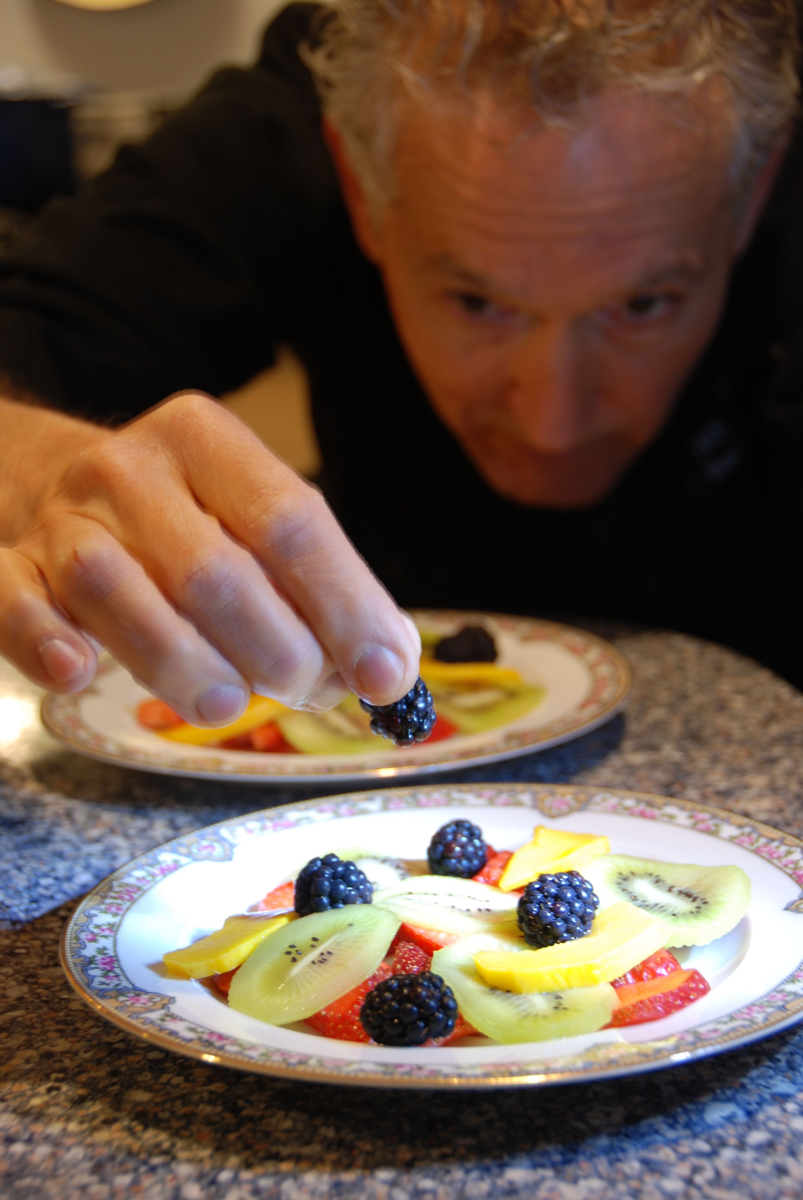 A person serving fruit from a plate.