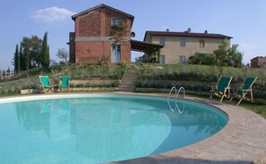 A swimming pool with a brick building in the background.