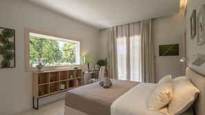 A bedroom with a large bed, a desk, a chair, a window with curtains, and a shelf with books and decorative items. - Tenuta DonnAnna (Galatone)