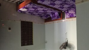 Una habitación con ventana, ventilador de pared y ventilador de techo.