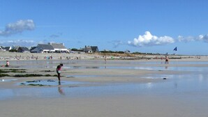 Una spiaggia con persone, edifici e cielo sereno.