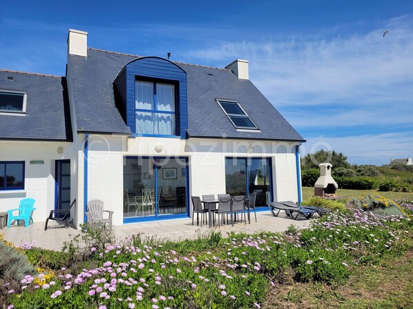 A two-story house with a large patio, outdoor seating, and a stone oven. - Tipoz'Immo-Les Galets- sea view house - fully equipped - pets welcome (Plozévet)