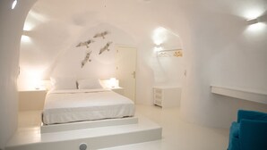 Une chambre à coucher moderne et minimaliste, avec un lit central, une petite table de chevet et un banc intégré.