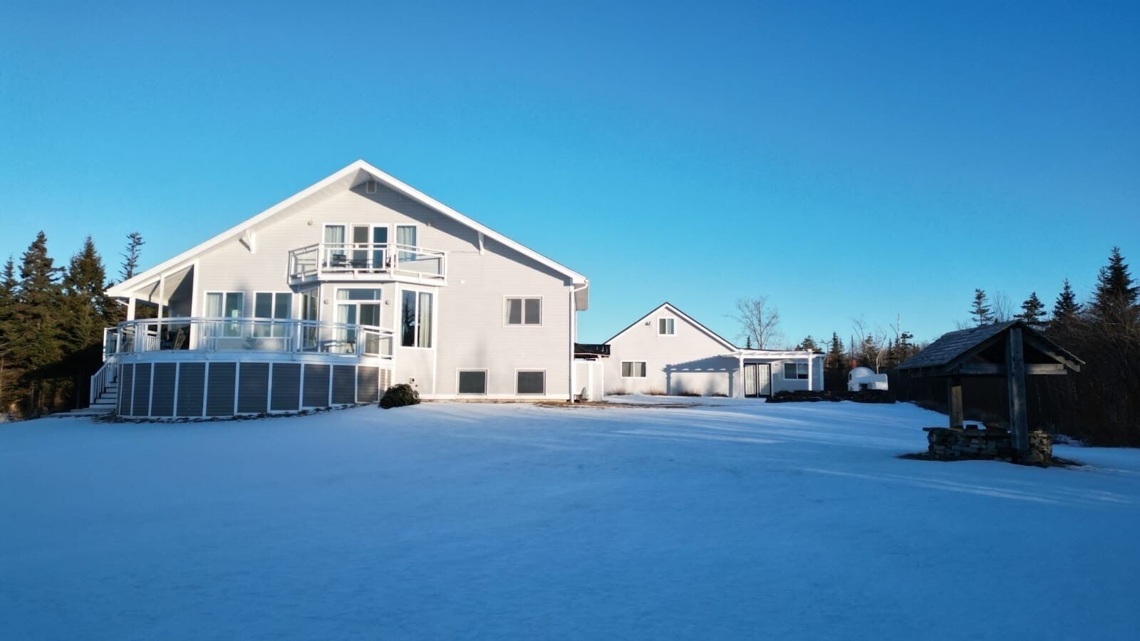 A large, modern house with a balcony and a smaller attached garage.