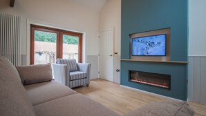 A living room with a sofa, striped armchair, and a fireplace.