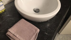 Een wastafel met een marmeren aanrechtblad en een handdoek.