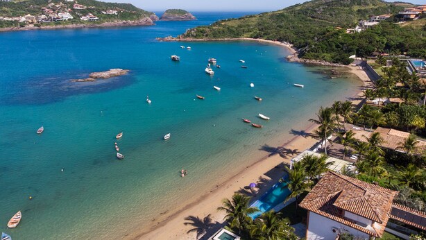 Zona costera con barcos, una playa y edificios.