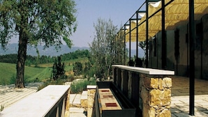 A modern building with stone pillars and a glass facade overlooking a green landscape. - Le Due Querce Agriturismo - Mimosa (Lazzeretto)