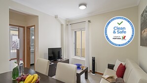 A modern living room with a dining area, a TV, and a balcony.