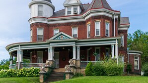 A large, historic Victorian-style house with a wrap-around porch, multiple chimneys, and a turret. - The Shepherd's Inn (Washington)