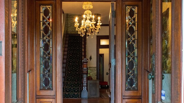 A grand entrance with a chandelier, ornate wooden doors, and a patterned carpet. - The Shepherd's Inn (Washington)
