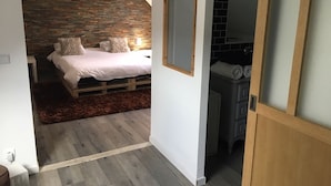 Une chambre à coucher avec un lit, une tête de lit en bois et un mur en briques.