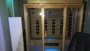 Un sauna avec une structure en bois, un banc et un appareil de chauffage.