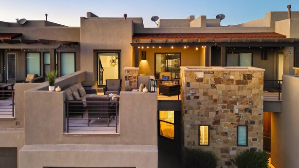 Un espacio al aire libre moderno con un muro de acento de piedra, asientos cómodos y un ambiente interior bien iluminado.