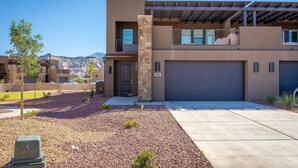 A modern two-story house with a stone pillar, a garage, and a landscaped driveway. - Fable House (St. George)