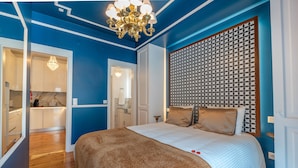 A bedroom with a large bed, a patterned headboard, and a chandelier. - Modern stylish studio in downtown Lisbon center - new to Vrbo (Lisboa)