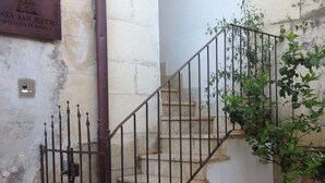A staircase with metal railings and a potted plant beside it. - Casa San Pietro Modica (Modica)