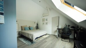 A bedroom with a bed, a desk, and a skylight. - Standard double room "B" (Bruyères-et-Montbérault)