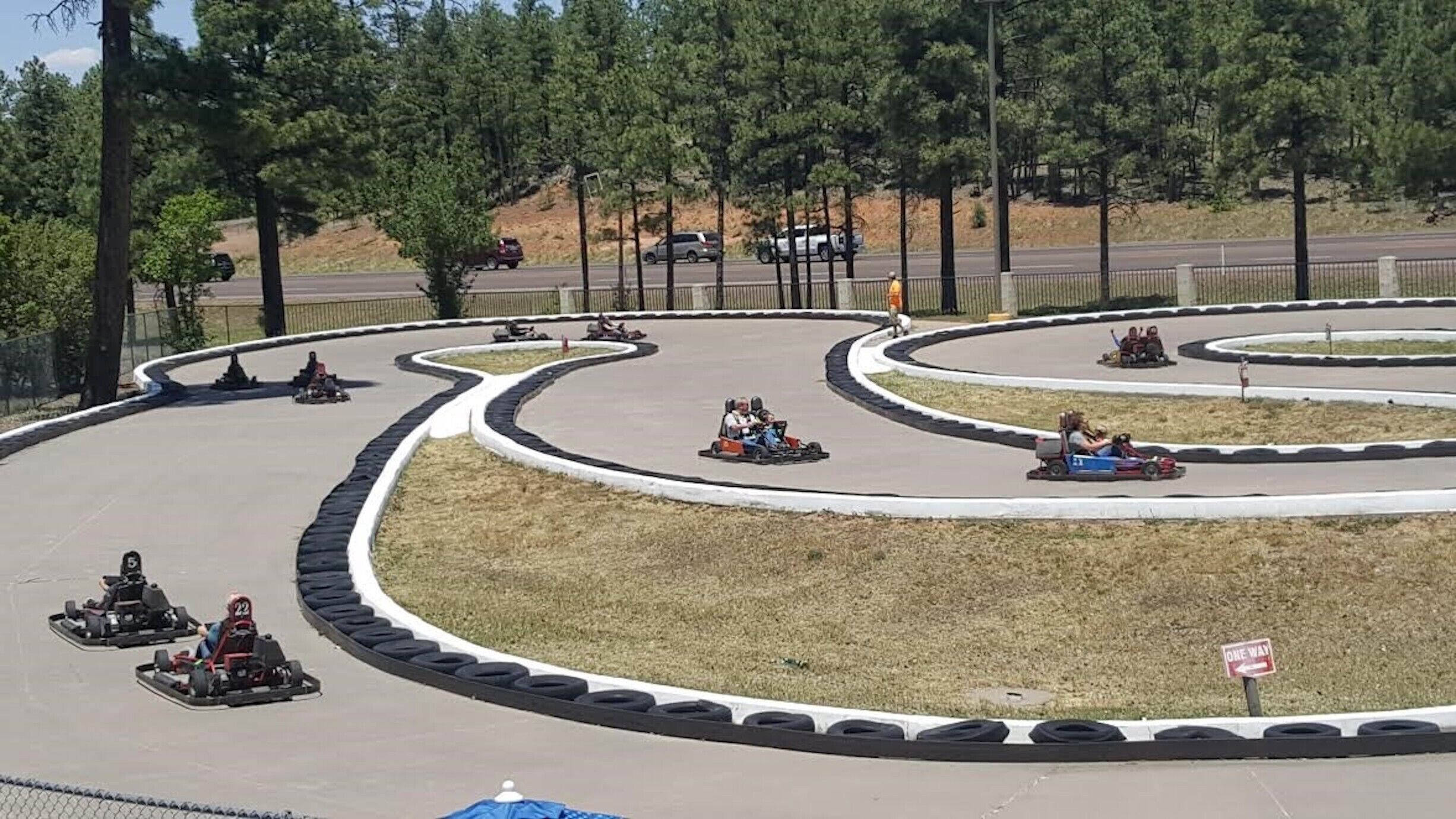 Une piste de karting avec plusieurs voies et une zone herbeuse au centre.