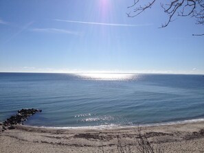 Een strand met heldere lucht en rustig water.