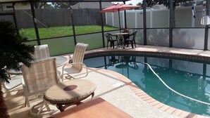 A backyard with a swimming pool, patio furniture, and a fenced area. - Beautiful 4 BR/2BA Private Pool Home Near Weeki Wachee Springs (Spring Hill, Florida, 34608)