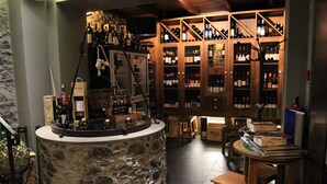 A wine cellar with stone walls, wooden shelves, and a central wine-making apparatus. - In pedestrianised Funchal Old Town | Taberna Apt 5 (Funchal)