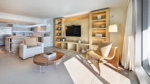 A modern hotel room with a living area, a kitchen, and a dining area.