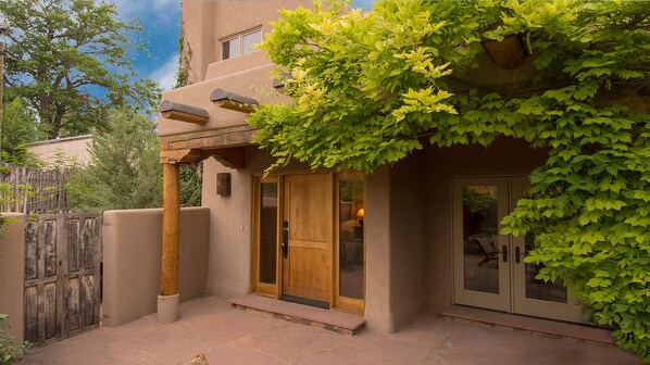 Stucco and wooden elements blend in harmony with lush green surroundings.