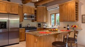 Enjoy cooking in this well-equipped kitchen with a central island, refrigerator, stove, and cabinetry.