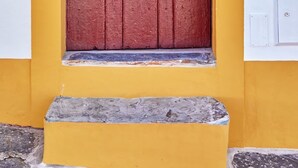 A red door with a small window and a sign reading "CORREIO" above it. - Veiros House / Estremoz II (Veiros)