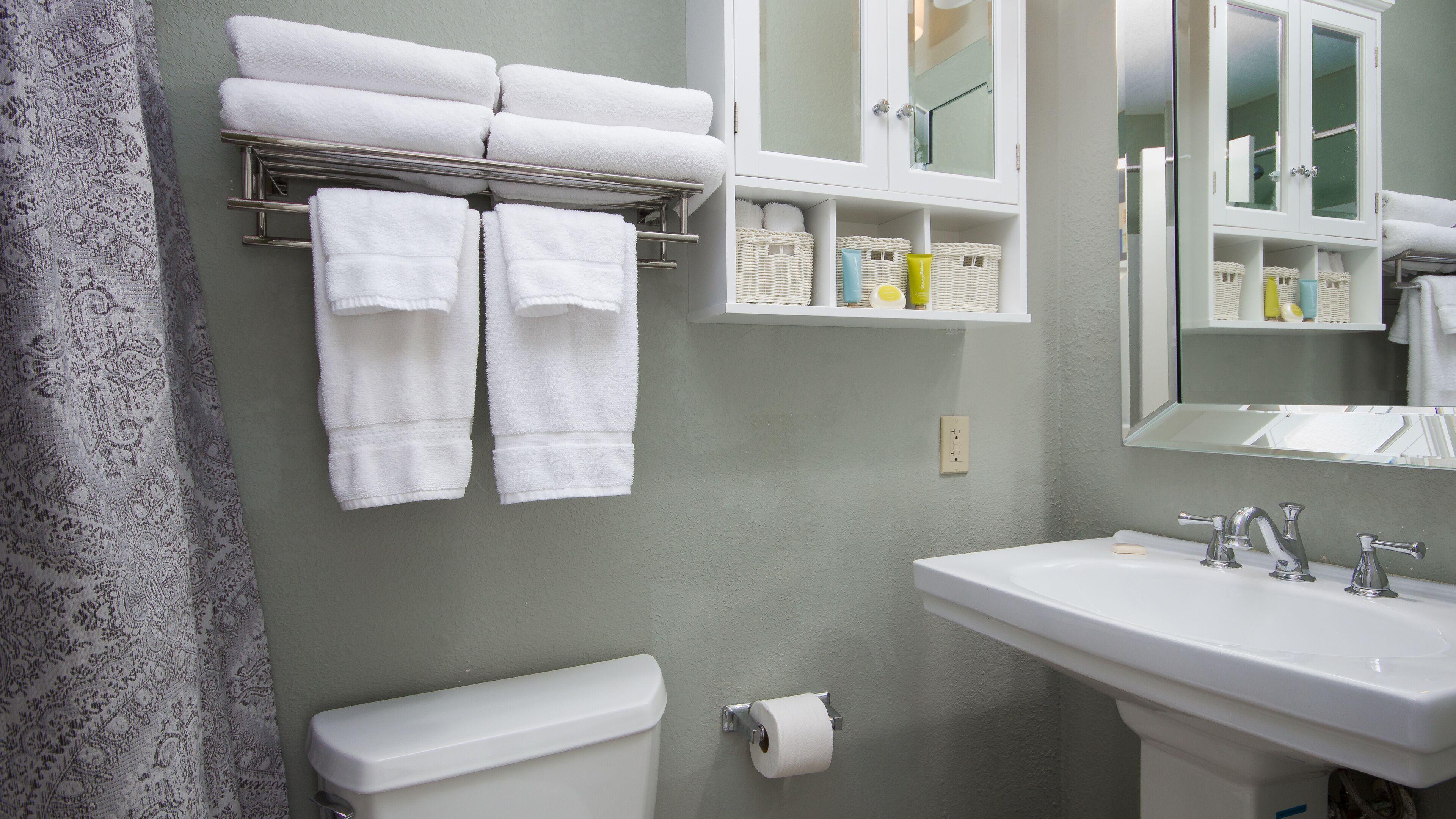 A bathroom with a toilet, sink, and towel rack.