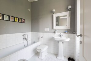 Tina con regadera, bidet, toallas, jabón 