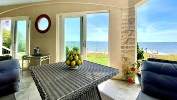 Enjoy a serene sea view from this room, featuring a wicker table, sofa, and a vase.