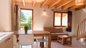 Un salon chaleureux avec une table en bois, un canapé et un escalier.
