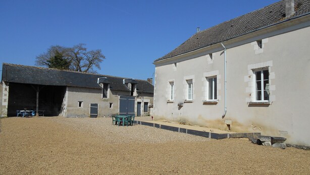 Un bâtiment doté de nombreuses fenêtres et d’une cour recouverte de gravier.