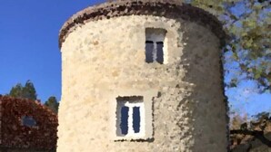 A stone tower with a small window and a door, surrounded by greenery. - atypical cottage with heated pool and covered in a beautiful & calm (Bruyères-et-Montbérault)