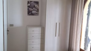 Une chambre à coucher comprenant une armoire, un lit et une œuvre d’art accrochée au mur.