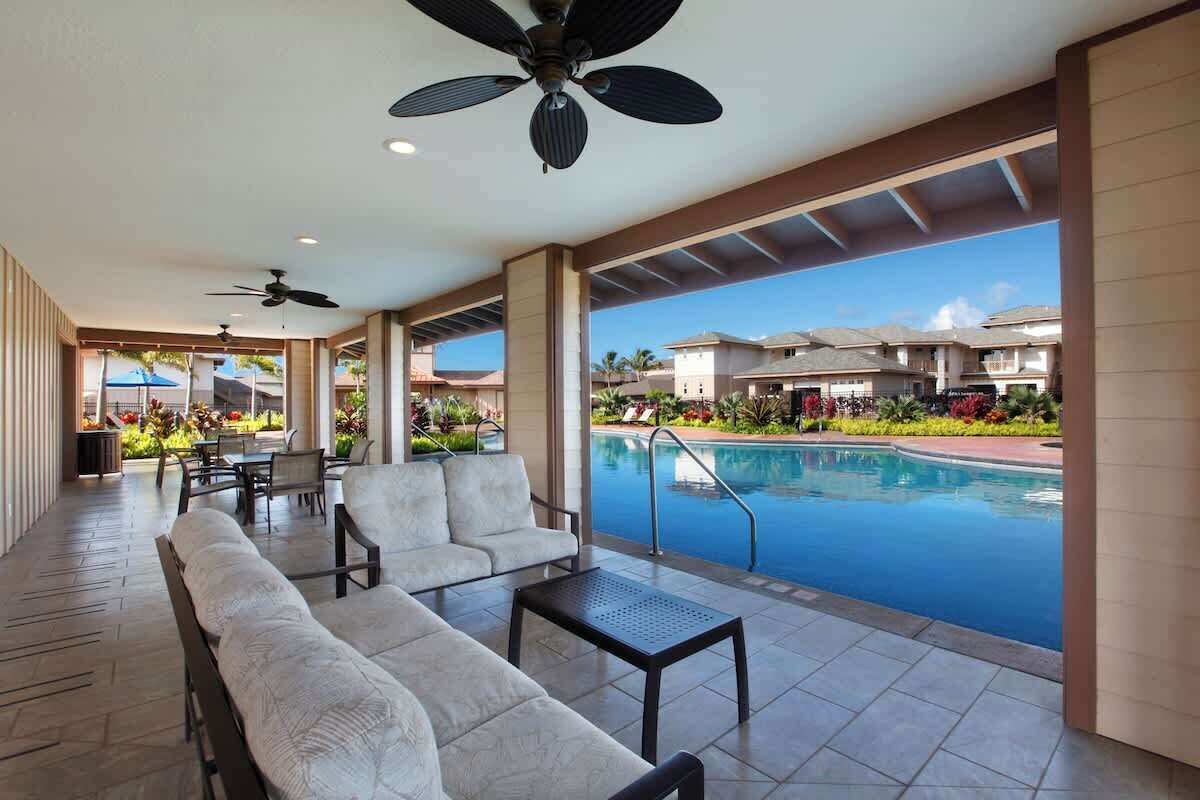 A poolside area with seating and a view of a swimming pool.