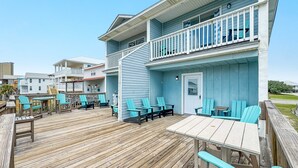 A two-story building with a wooden deck, outdoor seating area, and a balcony. - DOG FRIENDLY! EAST SIDE OF DUPLEX, PRIVATE BALCONY - BEACHBALL PROPERTIES (Gulf Shores)