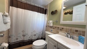 Bathtub, hair dryer, towels, toilet paper