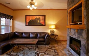 Relax in this inviting living room with a sofa, table, and fireplace.