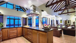 A spacious kitchen with large windows, wooden cabinets, and a central island. - Villa Maphraaw - 3 Bed, Sleeps 6 (Ko Samui)