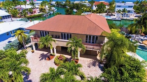 A coastal property with a red-tiled roof, a covered patio, and a view of the marina. - Beachy Keen House 3/2 Water View Pool Home with Dock (Marathon)