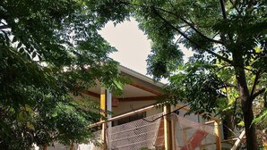 A building with a wooden staircase and a netted structure. - A stone's throw from the small beach of the Holy Land (Terre Sainte)