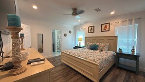 A bedroom with a bed, bedside table, lamp, and a ceiling fan. - Blue Marlin 2/2 Pool home with 35` Dock Easy Access to Atlantic (Marathon)